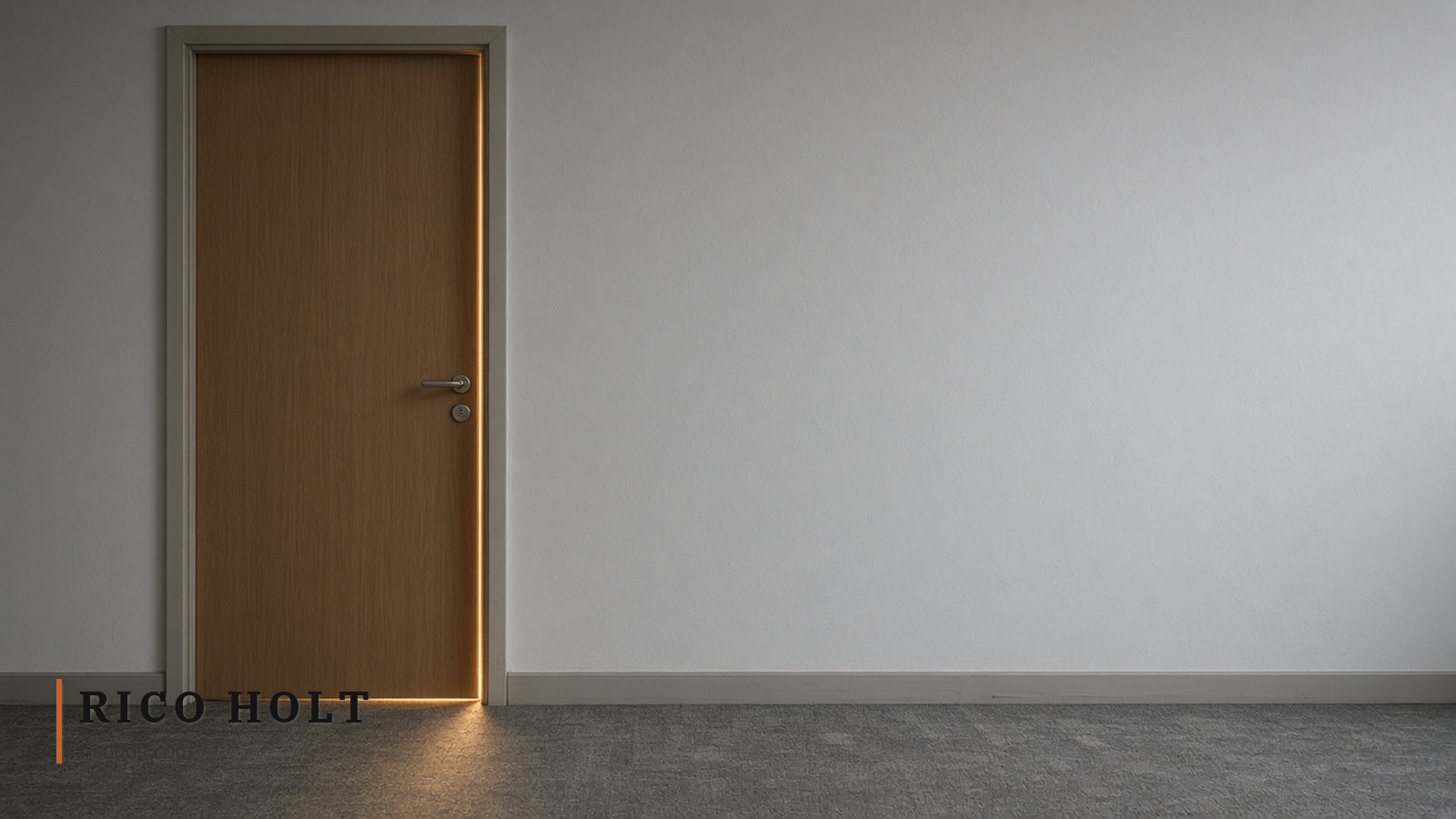 Closed timber meeting-room door off-centre left in a pale wall, warm amber light leaking onto worn grey carpet, empty after-hours office