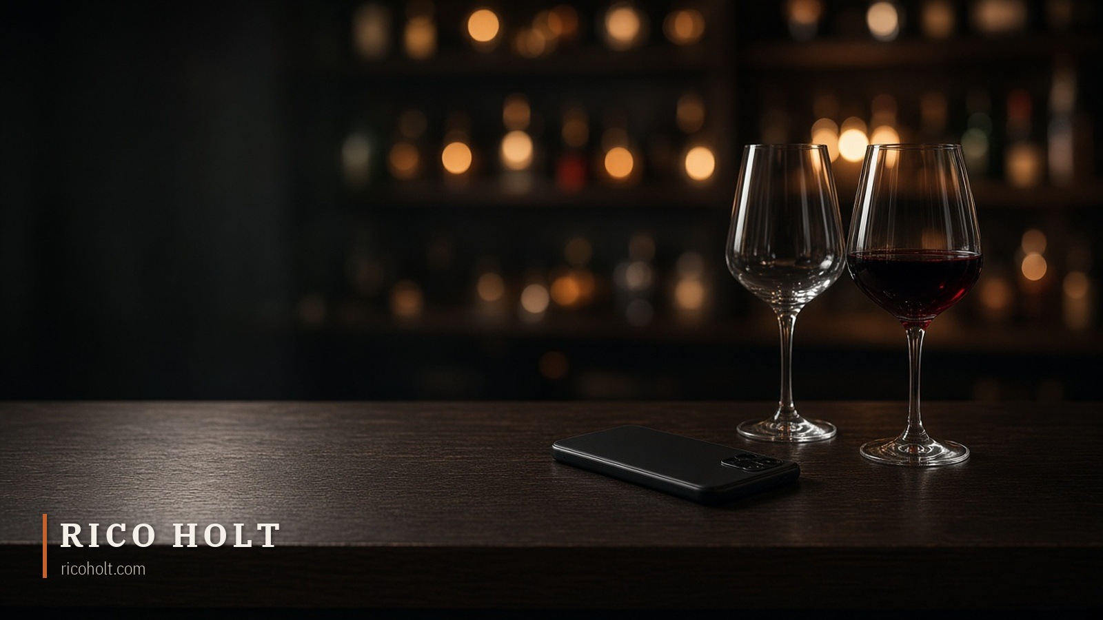 A phone lying face down on a dark bar table at night beside two wine glasses, one half-finished