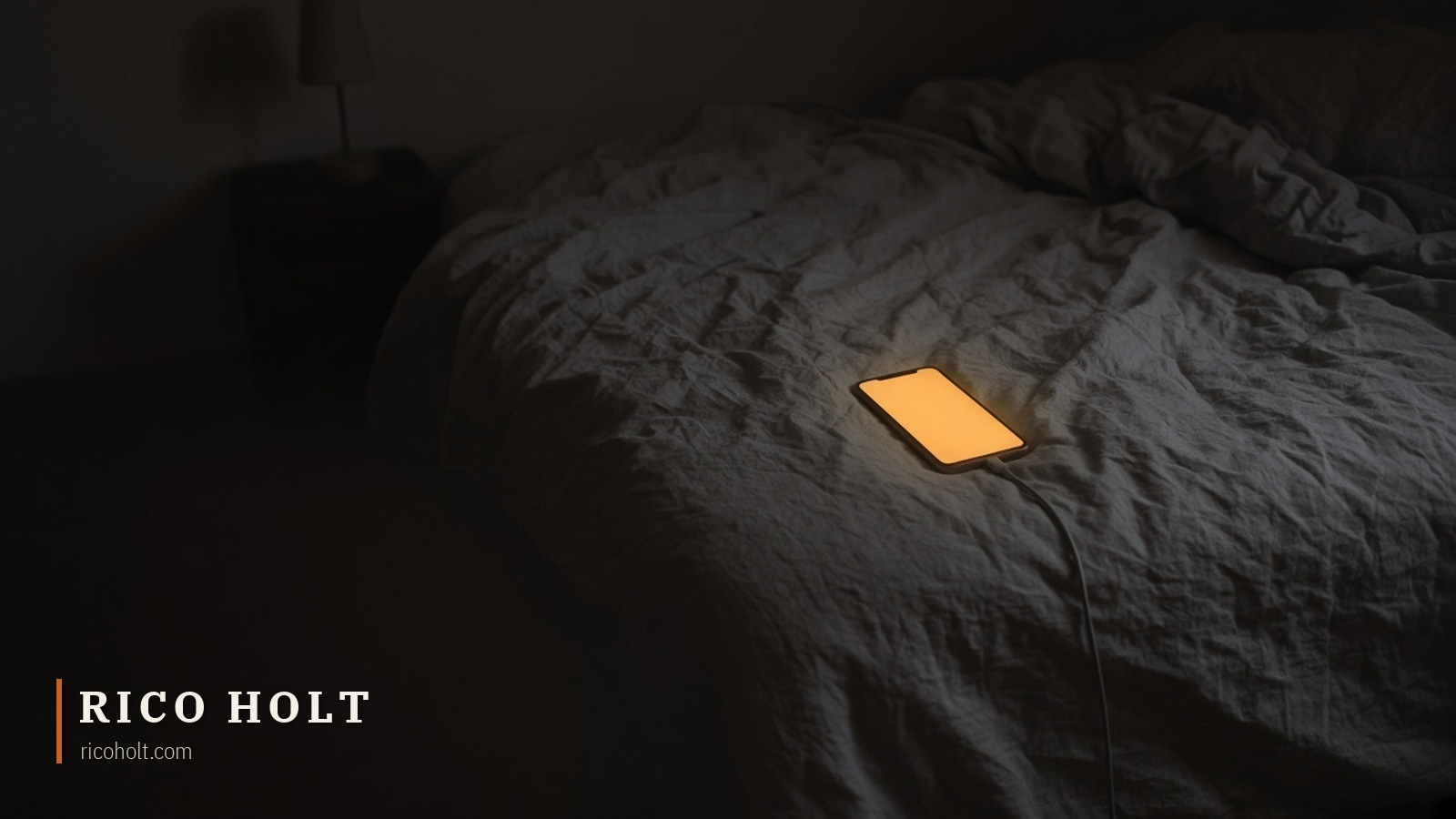 Phone face up on a kitchen table at night, screen glowing with soft abstract card shapes, empty coffee cup beside it, blinds half closed