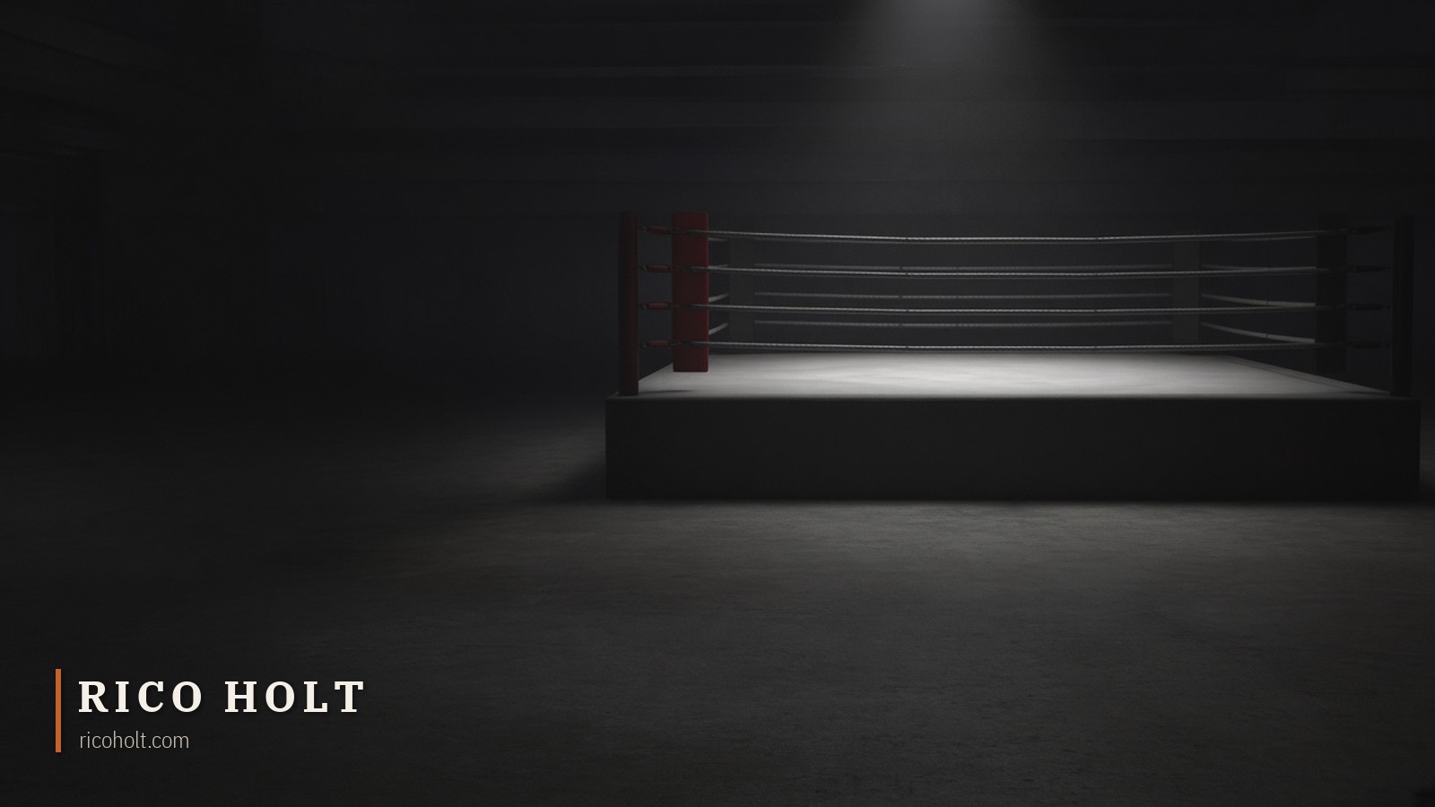 An empty boxing ring under a single light in a dark arena, one red corner pad
