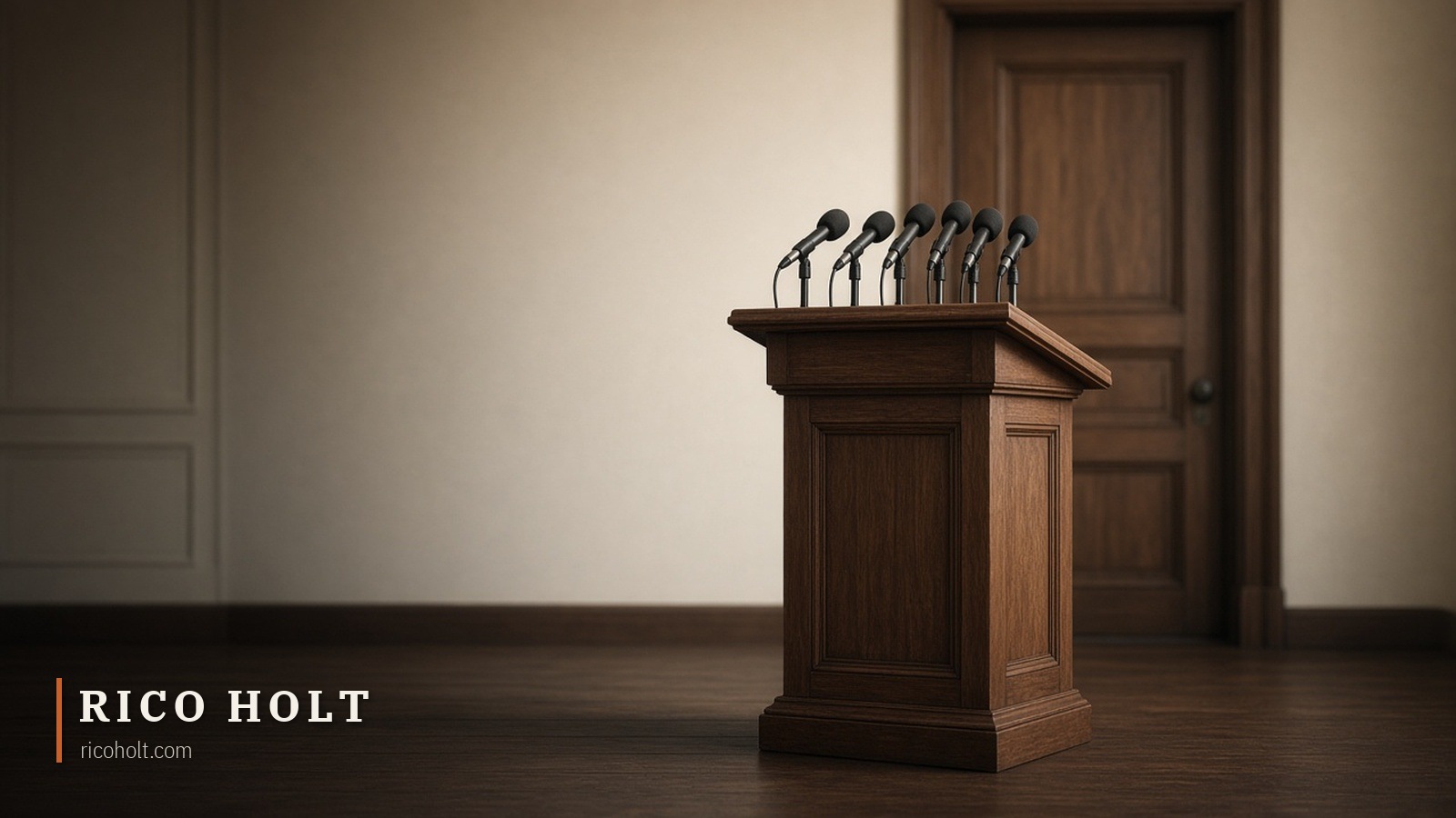 Empty wooden lectern with a cluster of microphones in front of closed tall panelled doors, soft daylight from the left, muted warm neutrals