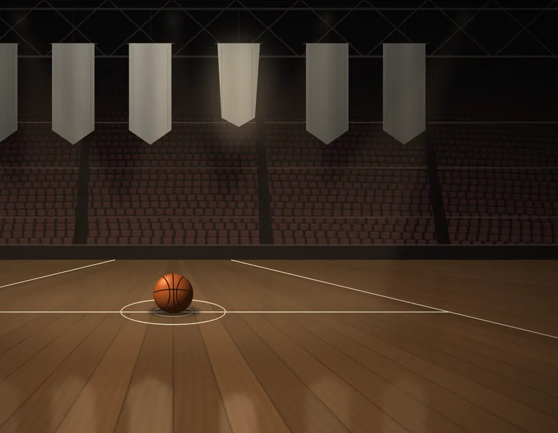 An empty basketball arena before tip-off, a ball resting on the centre circle under warm house lights, with plain blank banners hanging in the rafters
